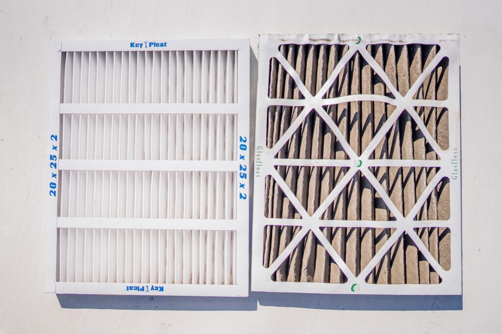 A dirty air filter next to a new clean filter