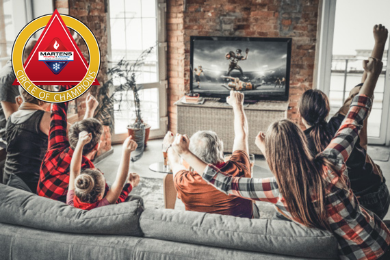 Happy family watching football in the living room.